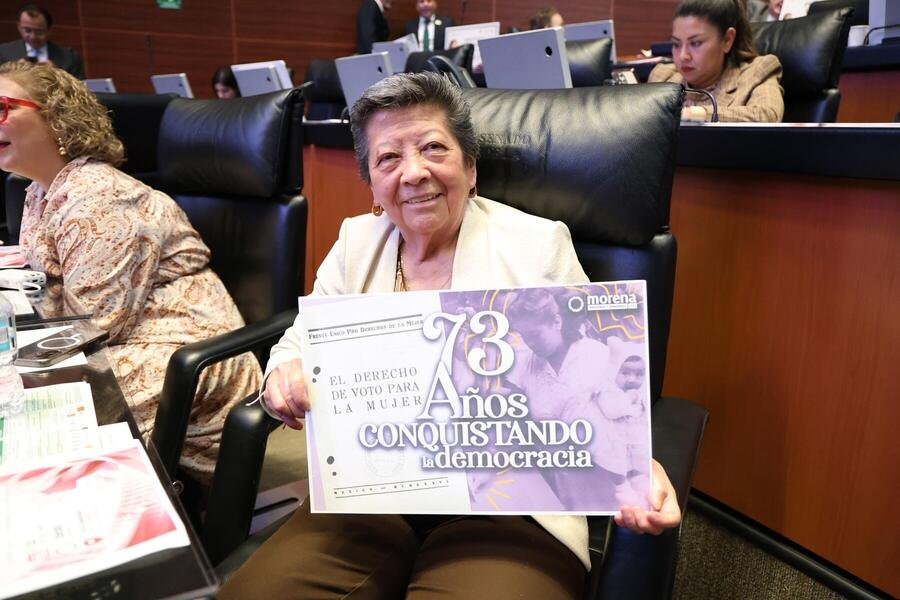 La senadora sostiene un cartel conmemorativo en el pleno